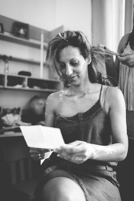 la mariée lit une lettre pendant qu'elle se fait coiffer