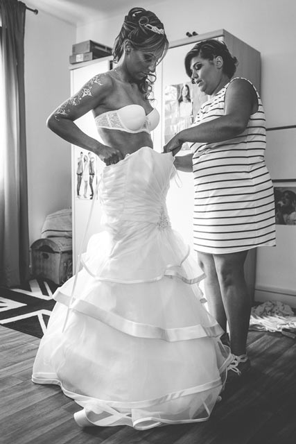 la mariée passe sa robe aidée par sa témoin