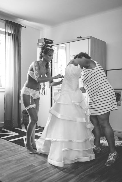 la mariée se prépare à enfiler sa robe