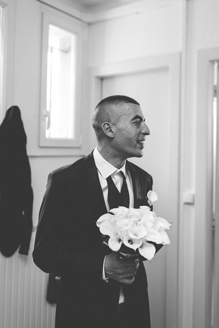 le marié attend sa future femme avec un bouquet à la main