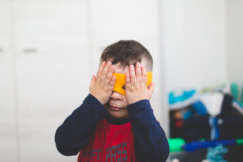 le petit garçon joue au super héro avec le photographe