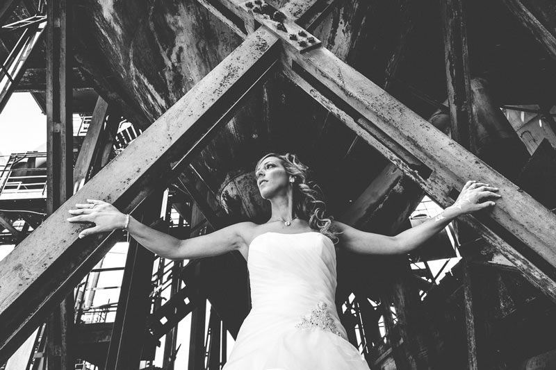 le photographe demande à la mariée de poser sur une structure metallique