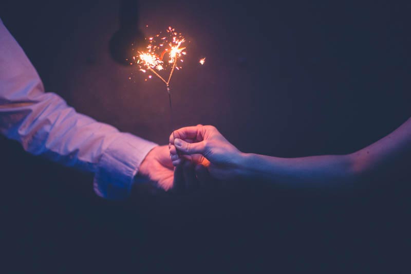 sparks on a candle held by the bride and groom