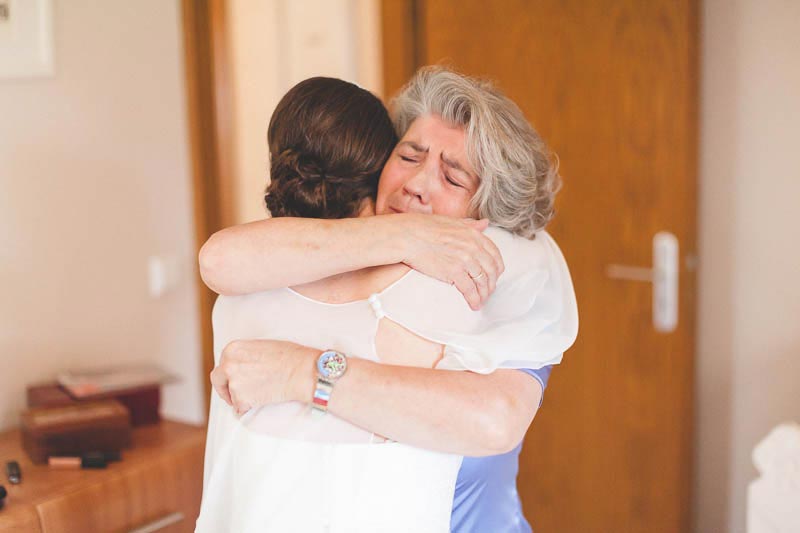 mom in tears falling in the arms of the bride