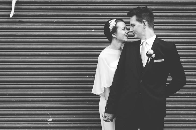 bride and groom in front of a iron curtain