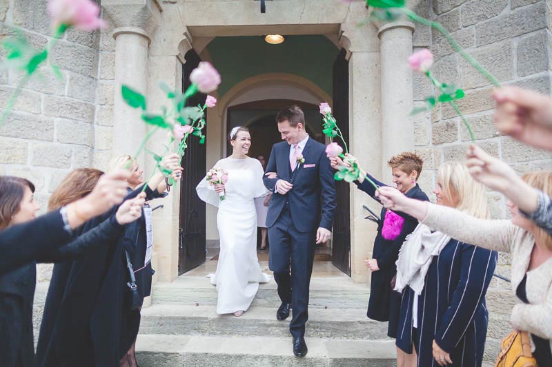 coming out of the church under a bed of roses