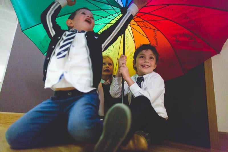 le photographe se glisse sous le parapluie avec les enfants