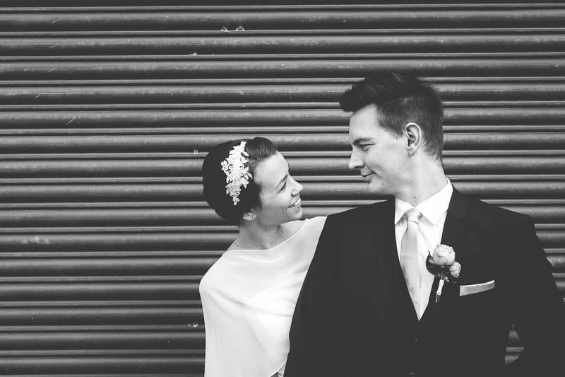 les maries en noir et blanc devant un rideau de fer