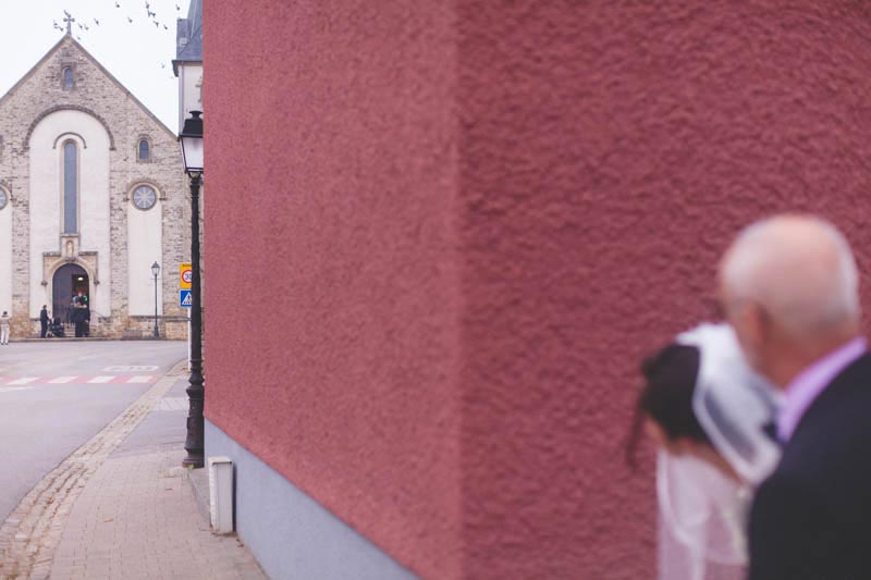 la mariée et son papa attendent avant d'entrer dans l'église