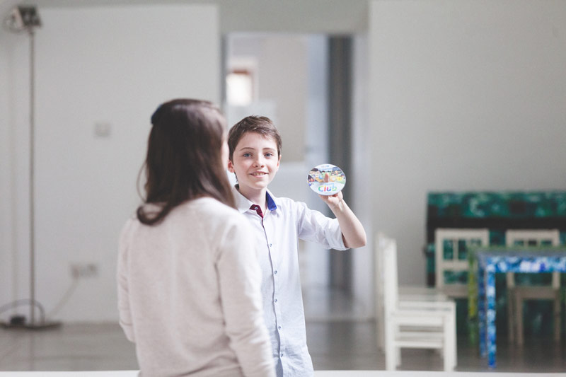 enfant souriant montre un cd de playstation a sa copine