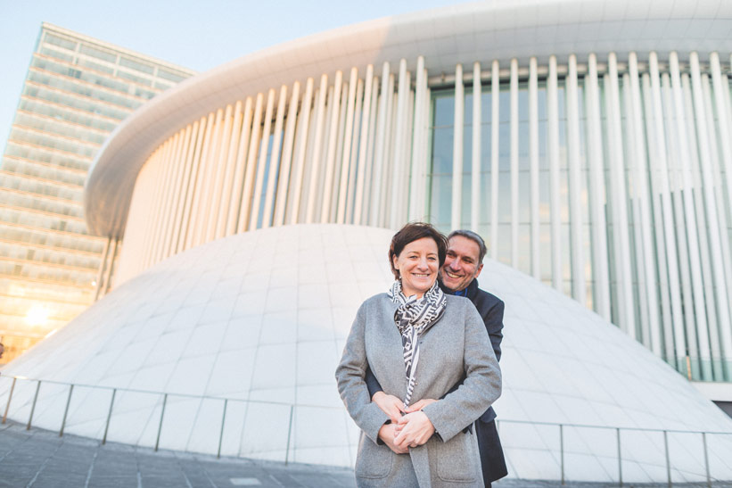 couple posant devant la philharmonie au coucher du soleil