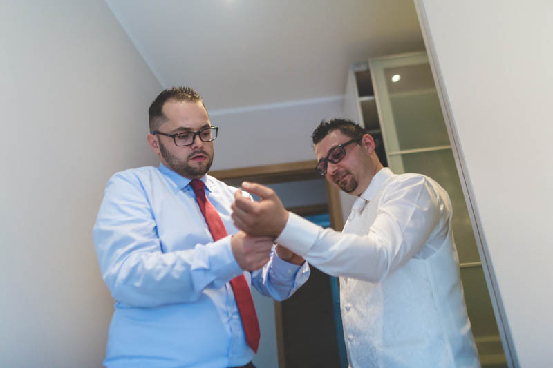 le témoin aide le marié avec les boutons de manchettes