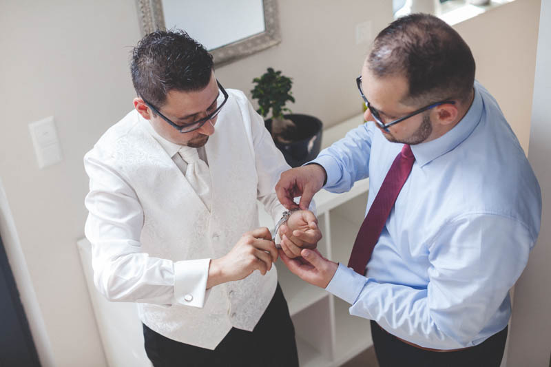 bestman fitting the watch on groom's wrist