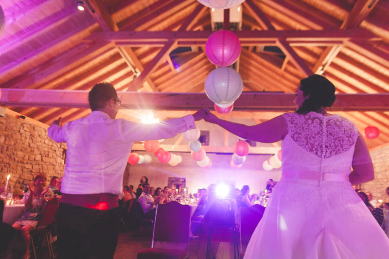 bride and groom standing while crowd applauds