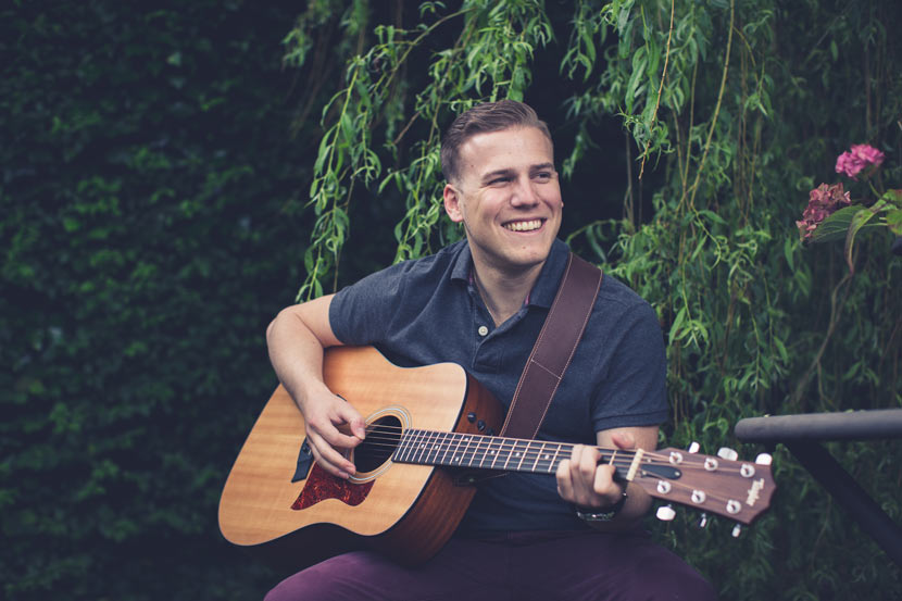 le fiancé joue de la guitare en souriant