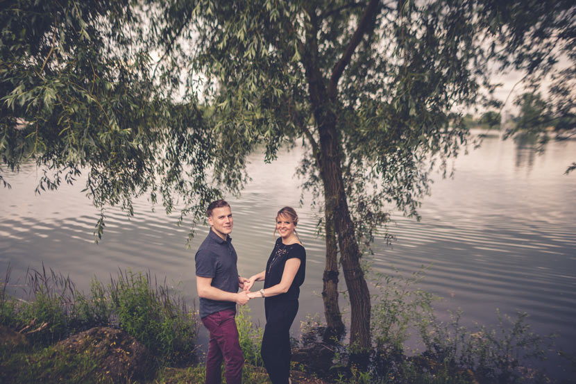 les futurs mariés se tiennent par les mains devant un lac