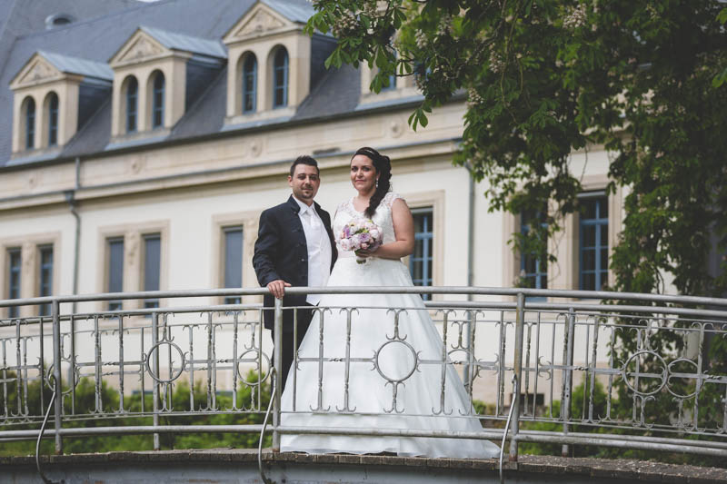 newlyweds crossing a bridge at mondorfs les bains parc