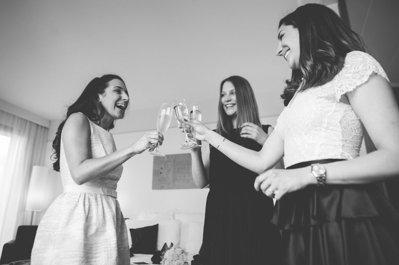 bride drinks champagne with her bridemaids