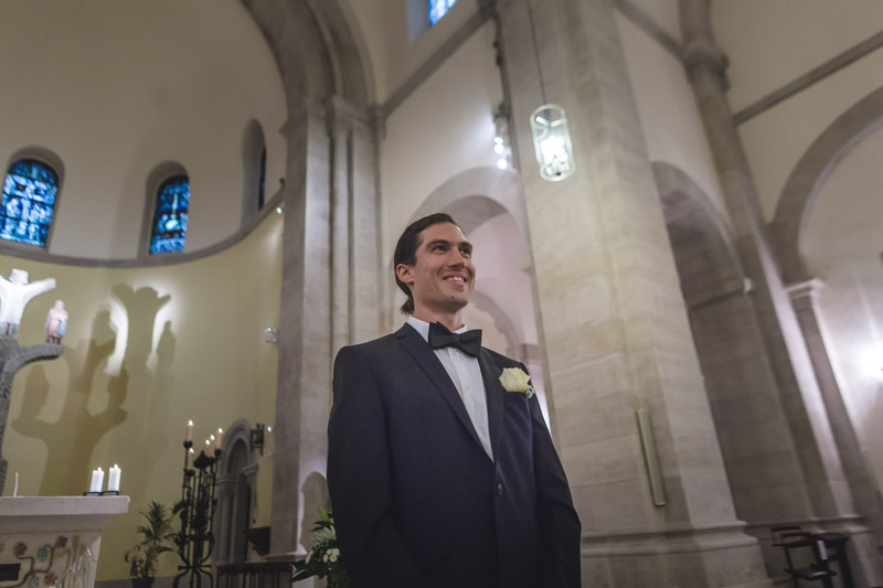 groom smiling while his wife shows u