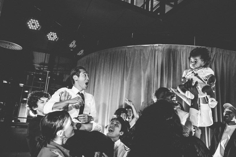 man carries baby at wedding party