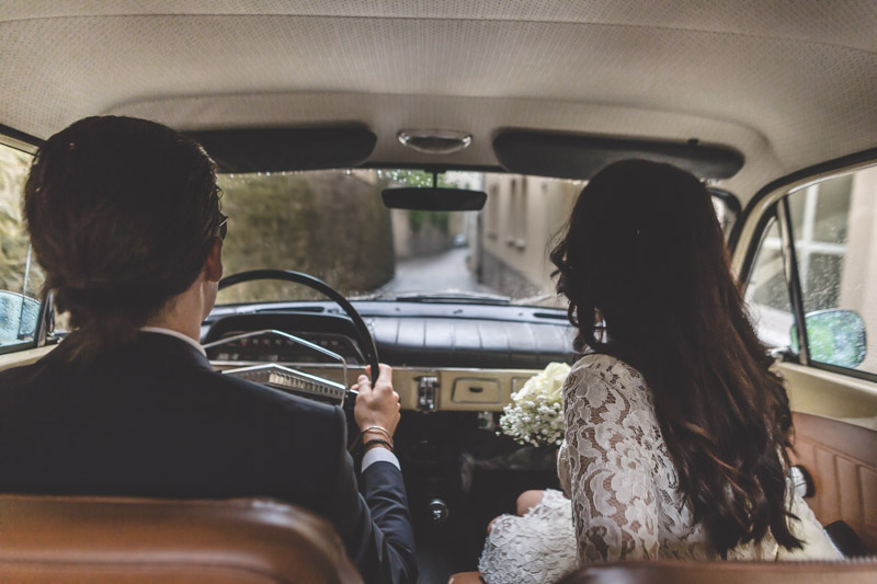 wedding photographer is in the car with the bride and groom