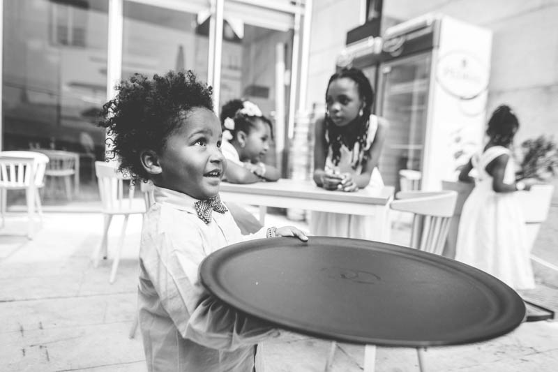 petit garcon noir jouant avec un plateau de serveur