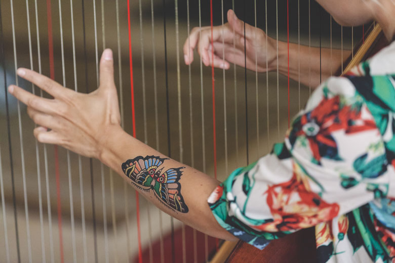 tatooed girl playing the harp