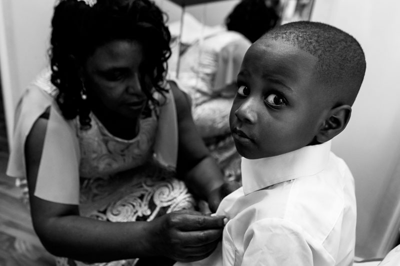 little boy is dressing up for the wedding