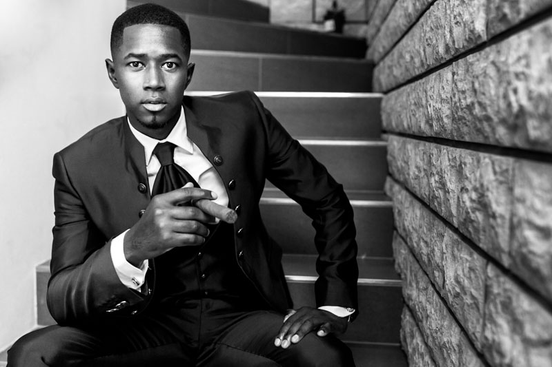 groom sittting in the stairs and smoking a big cigar