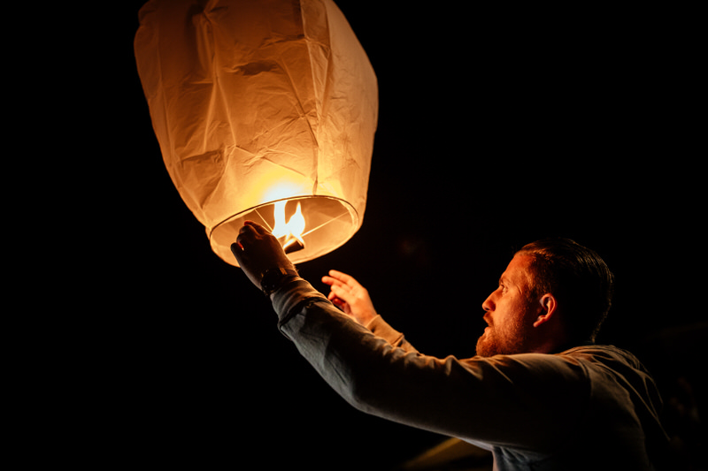 un homme allume une lanterne lors d'un mariage